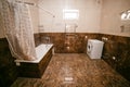 Bathroom in brown tones. large room with toilet, bath and washing machine