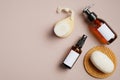 Bathroom cosmetics set on beige background. Flat lay, top view amber glass pump bottle, sprayer, body brush, natural soap. Beauty