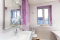 Bathroom covered white-purple tiled, mirror and sanitary engineering is in the apartment that is under construction, remodeling,