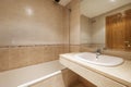 Bathroom with cream marble sink without cabinet with mirror integrated into the wall and with a long bathtub Royalty Free Stock Photo