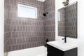 A bathroom with a dark vanity and brown tiled shower. Royalty Free Stock Photo