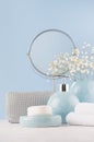 Bathroom decor for female in light soft blue color - circle mirror, silver cosmetic bag, white flowers, towel, soap and ceramic. Royalty Free Stock Photo