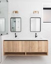 A bathroom detail with a floating with cabinet, marble tiles and gold lights.