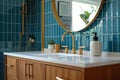 A bathroom detail with a gold faucet, wood cabinet, and blue tiles. Royalty Free Stock Photo