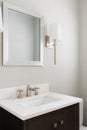 A bathroom detail with gold sconces and dark cabinet.