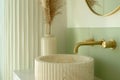 A reeded marble bathroom sink with a gold faucet.