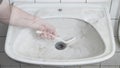 Bathroom dirty sink cleaning with brush, spray chemicals - housekeeping