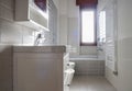 Bathroom with gray tile covering and floor-mounted sanitary fixtures and little window