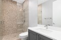 A bathroom with a grey cabinet and brown hexagon tile shower. Royalty Free Stock Photo