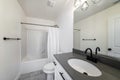 Bathroom interior with black fixtures and one piece shower tub with white shower curtain Royalty Free Stock Photo