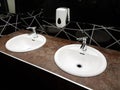 Bathroom interior in black and white. Round ceramic washbasins. Mirrors, plastic soap dish and chrome faucets for washing hands