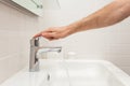 Bathroom interior. Bright bathroom with new tiles. New washbasin, white sink and large mirror. Hand open chrom water tap. Royalty Free Stock Photo