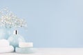 Bathroom interior - ceramic accessories - light blue circle vase with white flowers, soap dispenser , fluffy towels on white wood.