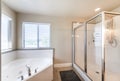 Bathroom interior with corner bathtub and shower stall with glass and aluminum frame