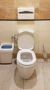 Bathroom interior in light beige and white colors. Oval ceramic toilet. Place of need for men. Restroom in public areas of urban Royalty Free Stock Photo