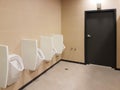 Bathroom interior in light beige and white colors. Oval ceramic urinal. Place of need for men. Restroom in public areas of urban Royalty Free Stock Photo