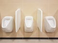 Bathroom interior in light beige and white colors. Oval ceramic urinal. Place of need for men. Restroom in public areas of urban Royalty Free Stock Photo