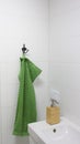 Bathroom interior in light colors with sink, bamboo soap dispenser and green towel