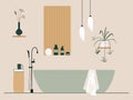 Bathroom interior. New stylish renovation in the bathroom with bathtub, home plants, lamps, book and and bath accessories. Royalty Free Stock Photo