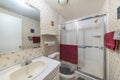 Bathroom interior with pink floral print wallpaper design and shower stall with glass and aluminum