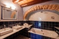 Bathroom interior in rustic style with stone arch and wooden beams.  Blue bathroom tile and double washbasin Royalty Free Stock Photo