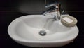 Bathroom interior with sink and faucet. Modern apartment in the attic of the house. White ceramic washbasin with chrome tap on a Royalty Free Stock Photo