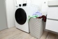 Bathroom interior washing machine with laundry basket full to the top