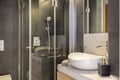 Bathroom interior with white, ceramic washbasin and shower cabin