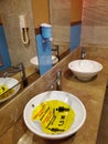 Bathroom interior with yellow sticker in sink about keeping social distance