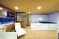 Bathroom with Jacuzzi, white sink, mirrors and Finnish sauna cabin with glass door Royalty Free Stock Photo