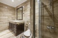 Bathroom with marble tiled walls, wood framed mirror