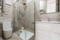 Bathroom with marble walls, square frameless mirror, white vanity