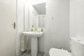 Bathroom with matching pedestal white porcelain sink, square frameless