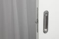 Bathroom metallic doorknob with lock over a white door