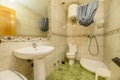 Bathroom with mirror framed by a border of tiles, green stoneware floors