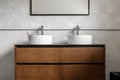 Bathroom modern vanity unit with two round ceramic sinks, chrome faucets and mirror with black frame Royalty Free Stock Photo