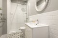 Bathroom with one piece sink, white framed round mirror