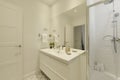 Bathroom with one-piece white porcelain sink, large frameless wall mirror