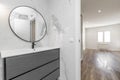 Bathroom with porcelain sink on gray dresser, circular mirror Royalty Free Stock Photo