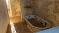 Bathroom and rusted bath filled with sand, walls are cracked and paint peeled off at the ghost town of Kolmanskop, Namibia