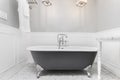 A bathroom`s clawfoot tub on marble tiles. Royalty Free Stock Photo