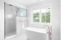 A bathroom`s freestanding tub and marble tiled shower. Royalty Free Stock Photo