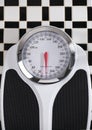 Bathroom Scale on Black and White Tile Floor Royalty Free Stock Photo