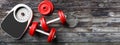 Bathroom scale, dumbbells on an old wooden floor background. Copyspace for text. 3d illustration