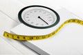 Bathroom scale with a measuring tape on background Royalty Free Stock Photo