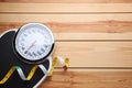 Bathroom scale, measuring tape and space for text on wooden floor, top view. Weight loss concept Royalty Free Stock Photo