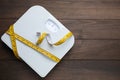 Bathroom scale, measuring tape and space for text on wooden floor, top view. Weight loss concept Royalty Free Stock Photo