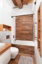 A bathroom shower detail with wood and white tiled walls.