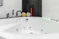 Bathroom with shower and large Jacuzzi bathtub with contrasting white and black walls Royalty Free Stock Photo