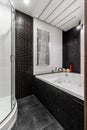 Bathroom with shower and large Jacuzzi bathtub with contrasting white and black walls Royalty Free Stock Photo